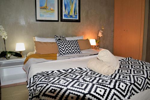 um quarto com uma cama com um edredão preto e branco em Porto Santo Balcony View House em Porto Santo