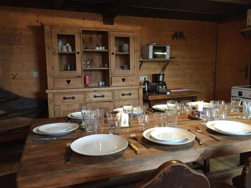 une table en bois avec des assiettes et des verres dans l'établissement Chalet Le Paddock, à Saint-Gervais-les-Bains