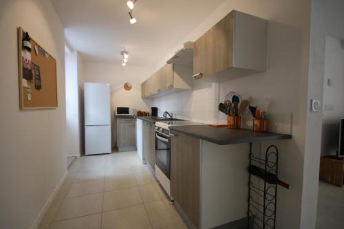 a kitchen with a refrigerator and a counter top at Cottage at 7 in Sainte-Foy-la-Grande