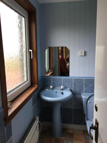 a bathroom with a sink and a mirror and a toilet at Garvault House in Kinbrace