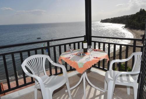 a table and two chairs on a balcony with the ocean at Giannis Maria Apartments in Psakoudia