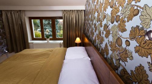 1 dormitorio con 1 cama y una pared con un mural en Residence Arx & Wellness, en Chrudim