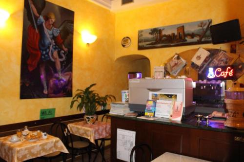 un ristorante con un bar con una cassa e due tavoli di Hotel Bolognese a Roma