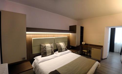 um quarto de hotel com uma cama grande e uma secretária em Donna Matilde em Pescocostanzo