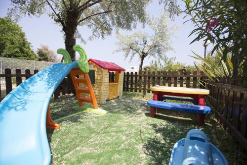 un parque infantil con tobogán y una casa de juegos en Hotel Bisanzio, en Cesenatico