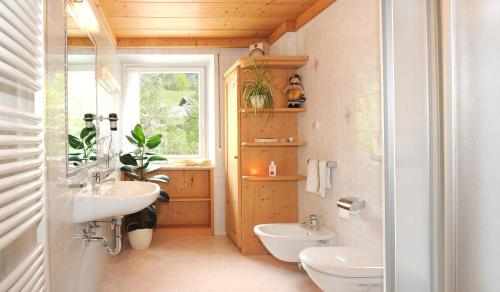 a bathroom with a sink and a toilet and a window at Haus Tannenburg in Funes