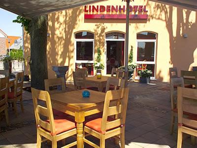a wooden table and chairs in front of a restaurant at AKZENT Hotel Altenberge in Altenberge