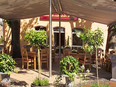 a patio with a table and chairs under a tent at AKZENT Hotel Altenberge in Altenberge