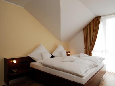 a bedroom with a white bed with a window at AKZENT Hotel Altenberge in Altenberge