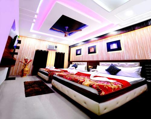 a large bedroom with two beds with red sheets at Taj Square A luxurious family homestay in Agra