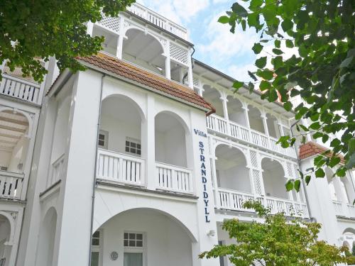 ビンツにあるVilla Strandidyll in Binz - WG 11 mit Meerblick und zwei Balkonenの青い看板の白い建物