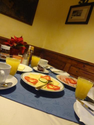 a table with plates of food and glasses of orange juice at Frühstückspension Doris Eder in Gaming