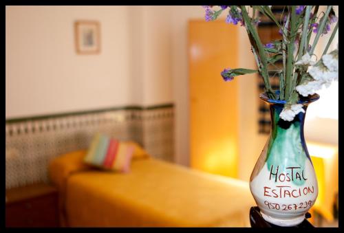 um vaso cheio de flores sentado numa mesa em Hostal Estación em Almeria