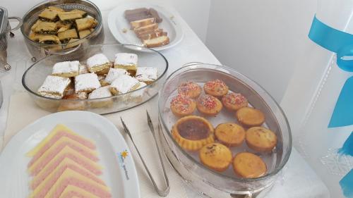 a table topped with plates of pastries and other desserts at Mata's Apartments in Tinos Town