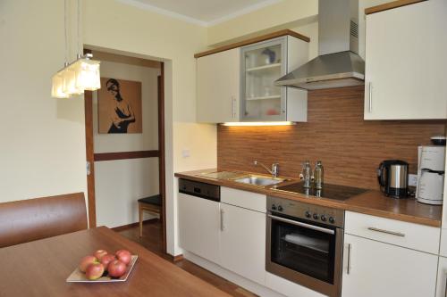a kitchen with white cabinets and a table with apples at Villa Castelli in Schladming