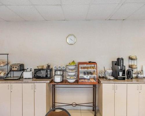 a kitchen with a counter with a clock on the wall at Econo Lodge in Smiths Falls