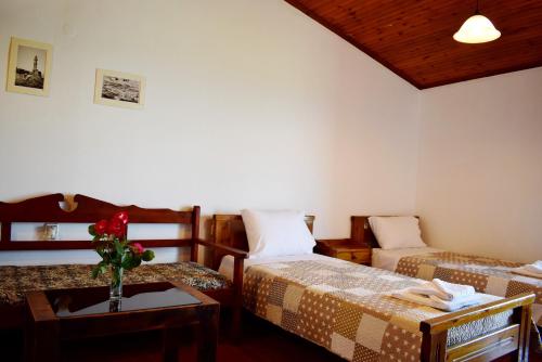 カラマキにあるPeace, comfort and spectacular sea view,3のベッド2台、花瓶付きのテーブルが備わる客室です。