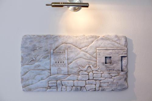 a painting of a building on a wall at Mata's Apartments in Tinos Town