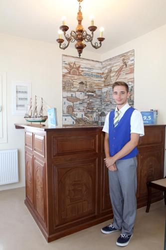a young man is standing in front of a counter at Mata's Apartments in Tinos Town