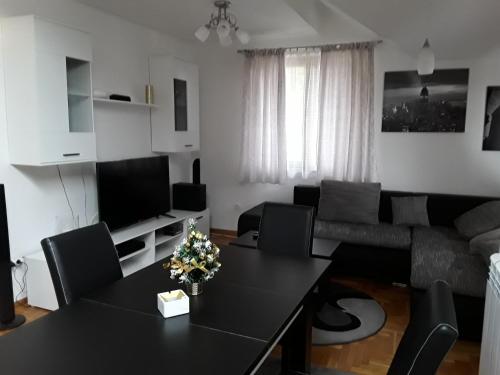 a living room with a black table and a couch at Apartmani Ivanovic in Zlatibor