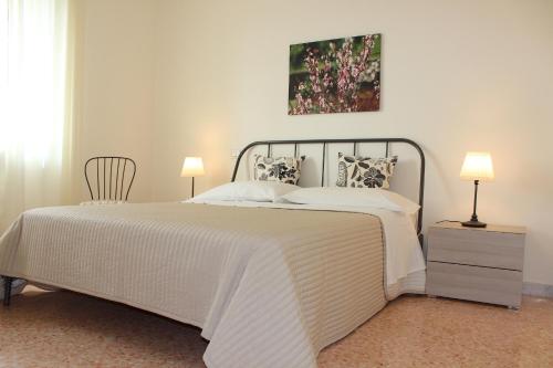 1 dormitorio con 1 cama grande con colcha blanca en Aduepassidalmare, en Monopoli