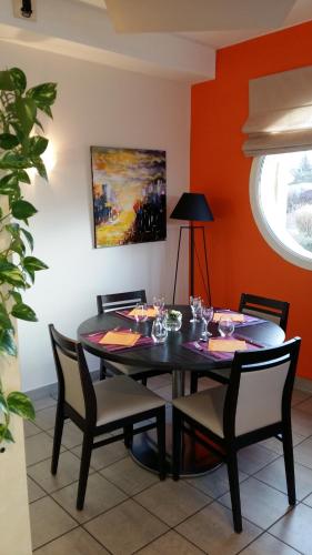 a dining room with a black table and chairs at Les Balcons Du Velay in Monistrol-sur-Loire