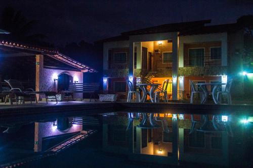 a house with a swimming pool at night at Pousada Doce Vida Guarapari in Guarapari