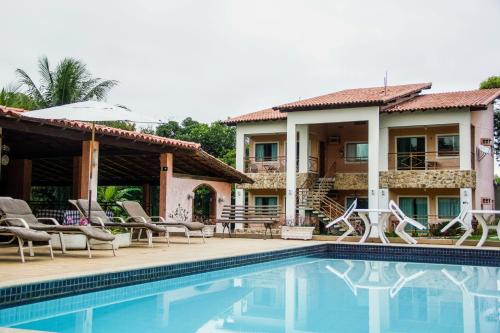 a villa with a swimming pool in front of a house at Pousada Doce Vida Guarapari in Guarapari