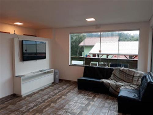 a living room with a couch and a large window at Pousada Farol do Arvoredo in Governador Celso Ramos