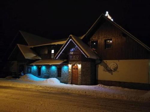 a building with blue lights in the snow at night at Šnekolend in Rokytnice nad Jizerou