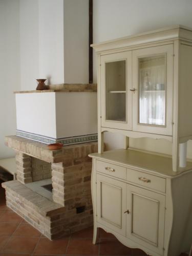 a kitchen with a white cabinet and a fireplace at La Capanna in Francavilla al Mare