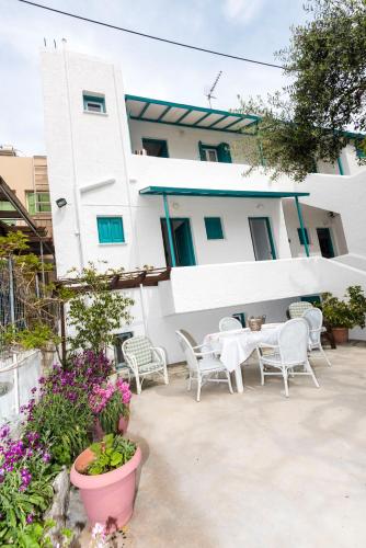 a patio with chairs and a table in front of a building at Avra Studios in Masouri