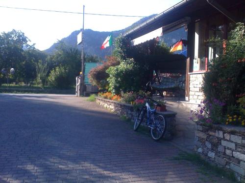 a bike parked next to a building with flowers at Campeggio Piano Grande in Baveno
