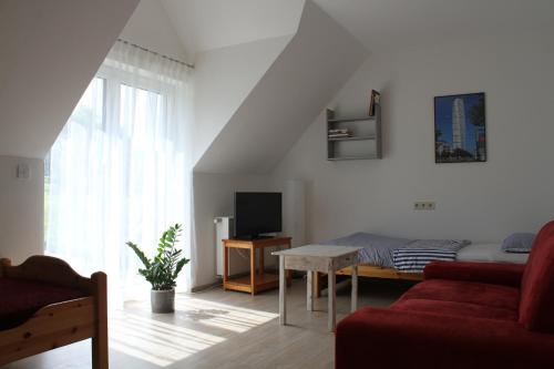 a living room with a red couch and a tv at Ferienwohnung I in Schnelldorf