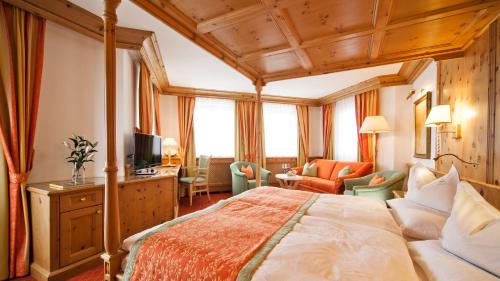 a hotel room with a bed and a television at Superior Hotel Tirolerhof - Zell am See in Zell am See
