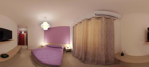 サン・ルーチドにあるB&B L'Incontroの紫色のソファとカーテン付きのリビングルーム