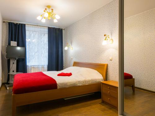 モスクワにあるApartment on Airportのベッドルーム1室(赤い毛布と鏡付きのベッド1台付)