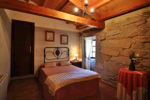 VilaboaにあるCasa do Americanoの石壁のベッドルーム1室(ベッド1台付)
