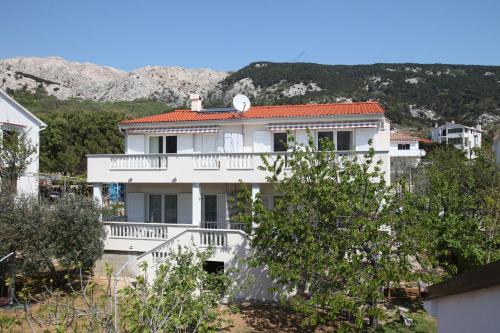 biały dom z balkonem i górami w tle w obiekcie Apartments with Terrace w Bašce