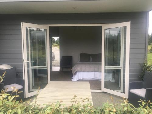 a screened in porch with a bed and sliding glass doors at Clydestay in Alexandra