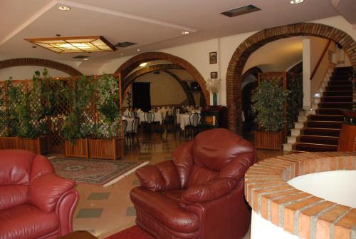 a lobby with leather chairs and a table with a dining room at Hotel Ristorante Farese in Melfi