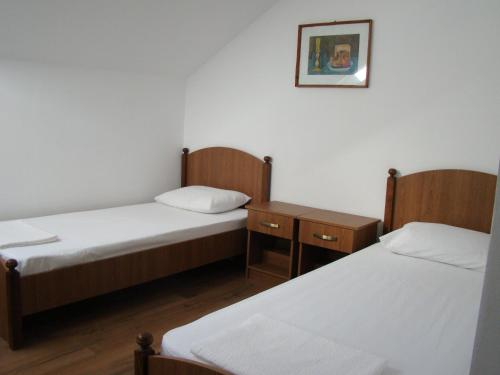 スチャヴァにあるCasa Horaのベッド2台が備わる部屋、壁に絵が飾られた部屋