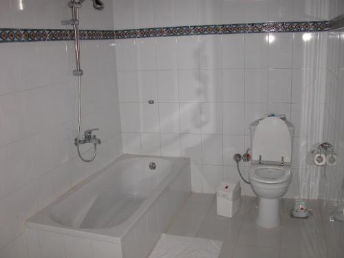 baño blanco con bañera y aseo en villa al diwan luxor en Luxor