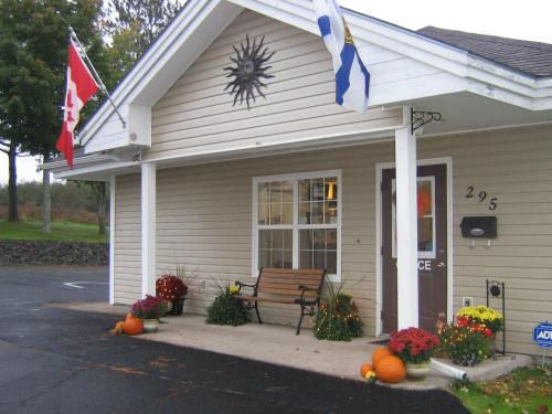 a house with a bench and flags in front of it at Antigonish Evergreen Inn in Antigonish