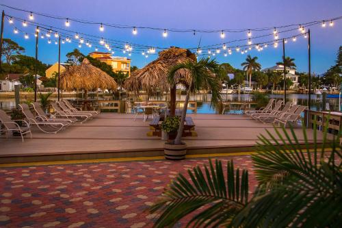 a deck with chairs and a table and lights at Bay Palms Waterfront Resort - Hotel and Marina in St. Pete Beach