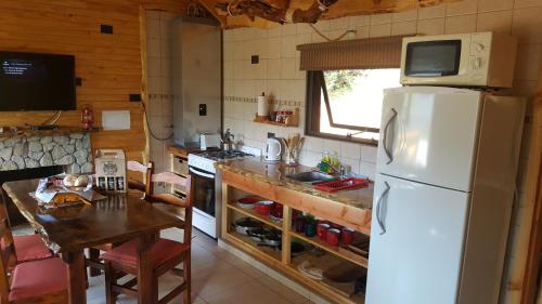 a kitchen with a white refrigerator and a table at Pendientes de Moquehue in Moquehue