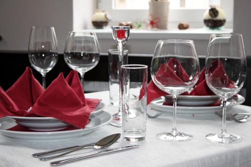 a table with wine glasses and plates and red napkin at Hotel Helios in Lipova Lazne