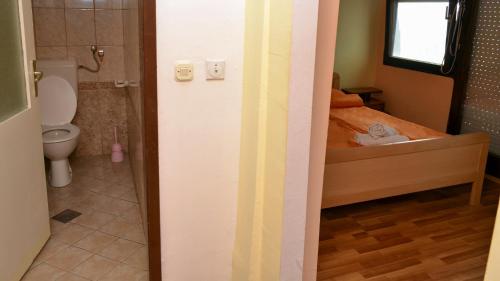 a small bathroom with a bed and a toilet at Apartments Villa Saray in Ohrid