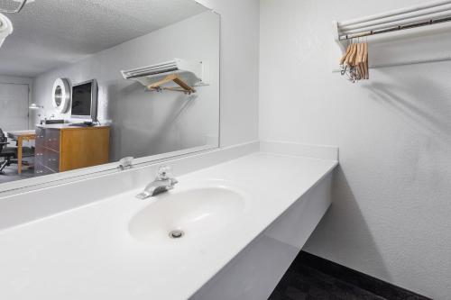 a white bathroom with a sink and a mirror at Knights Inn Flint in Flint