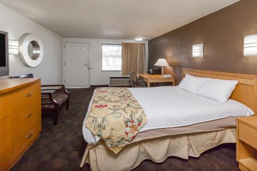 um quarto de hotel com uma cama grande e uma secretária em Knights Inn Flint em Flint
